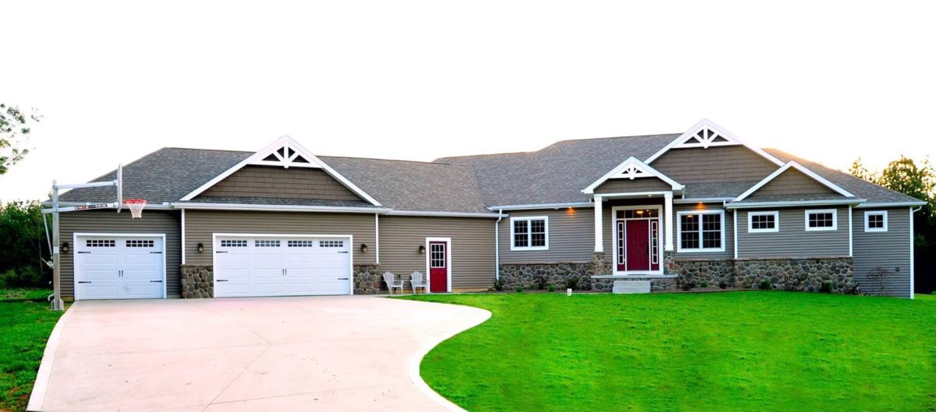 Custom ranch home with red front door and white garage doors