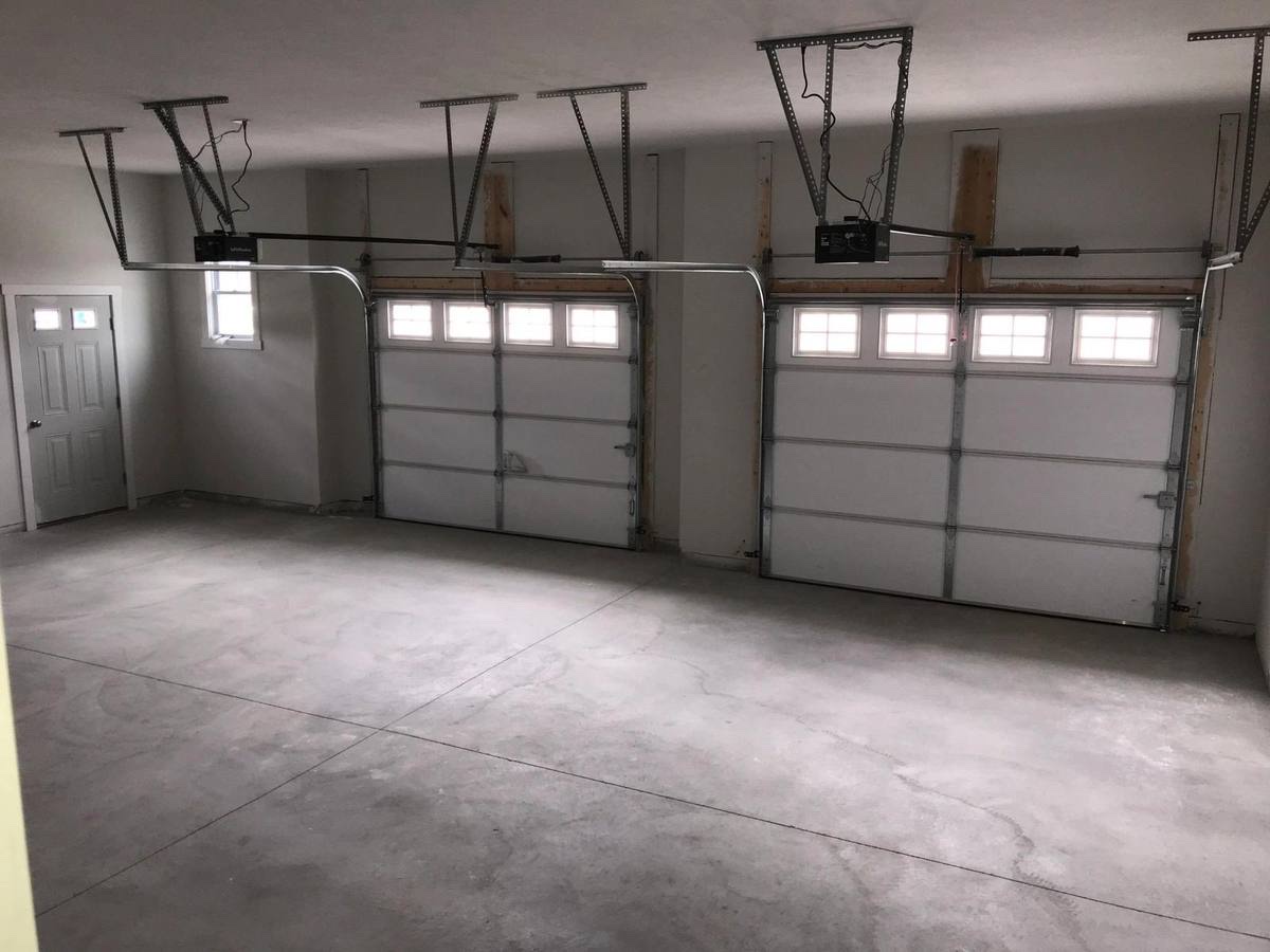 Finished two-car garage interior with concrete floor and overhead doors