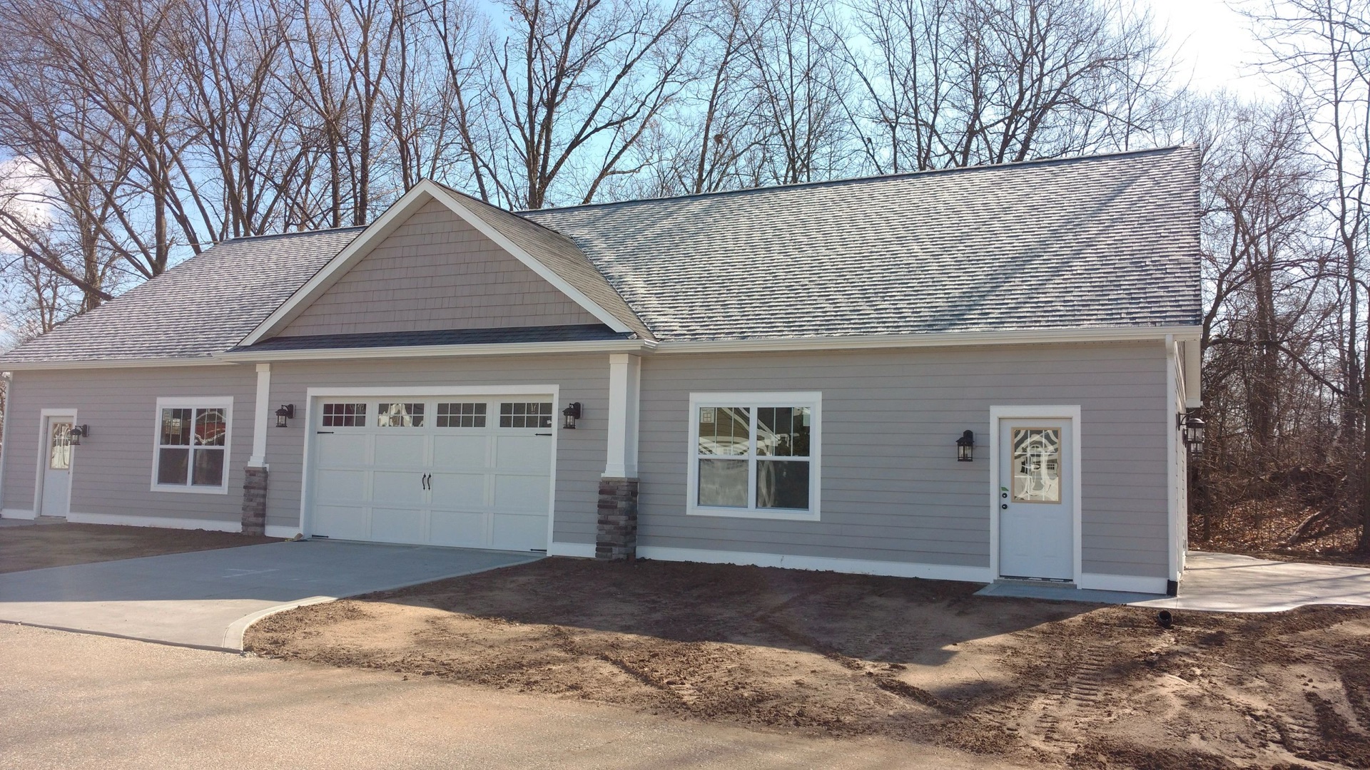 Custom craftsman toy barn with single wide garage door and stone pillar accents
