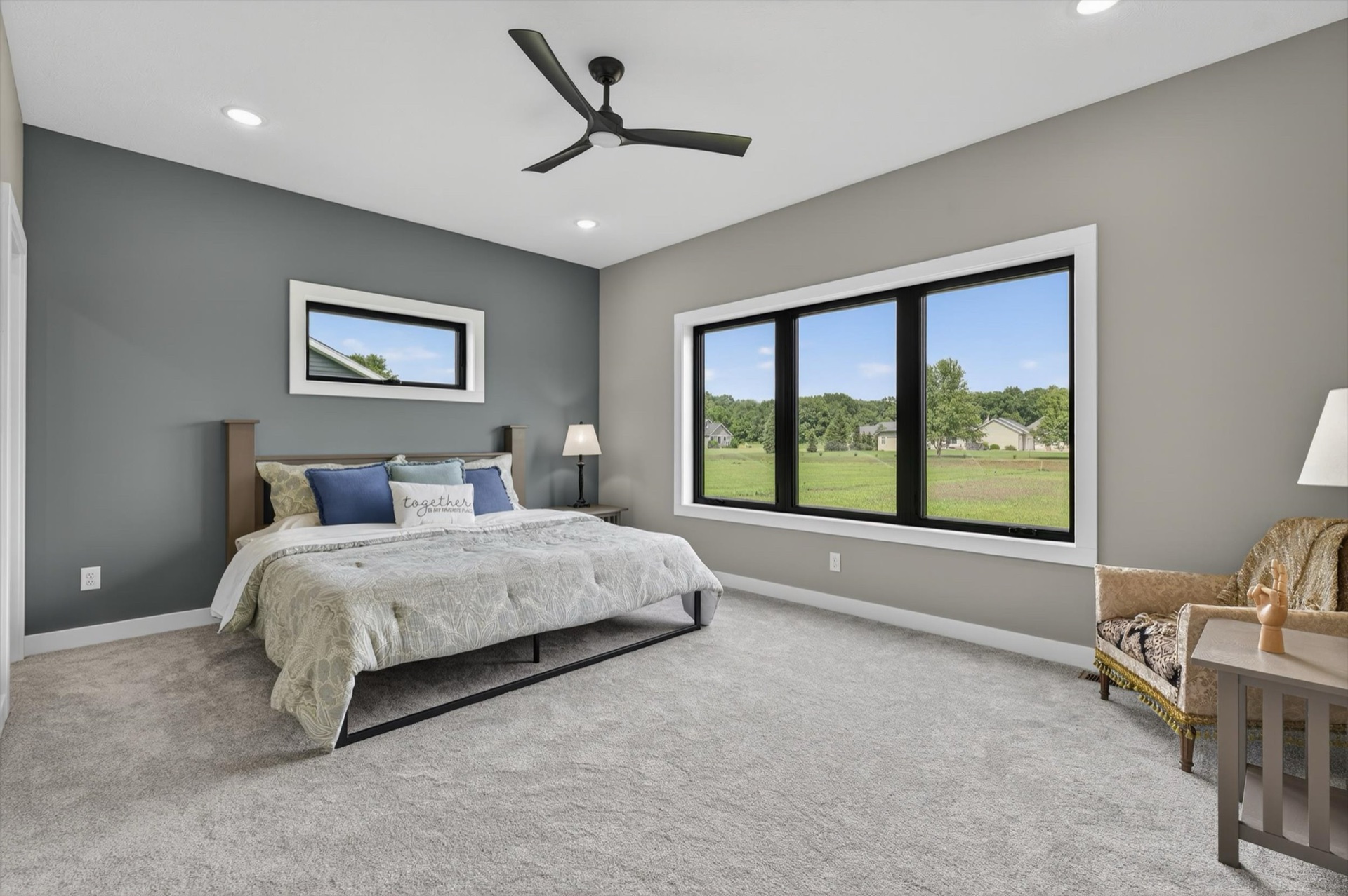 Custom master bedroom with ceiling fan, large windows, and plush carpet
