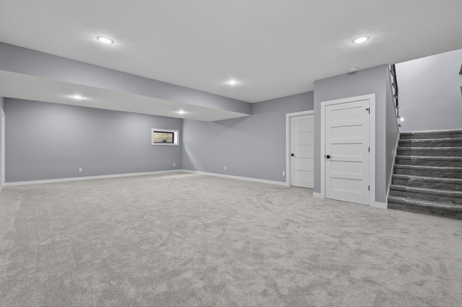 Finished basement with carpet, recessed lighting, and staircase